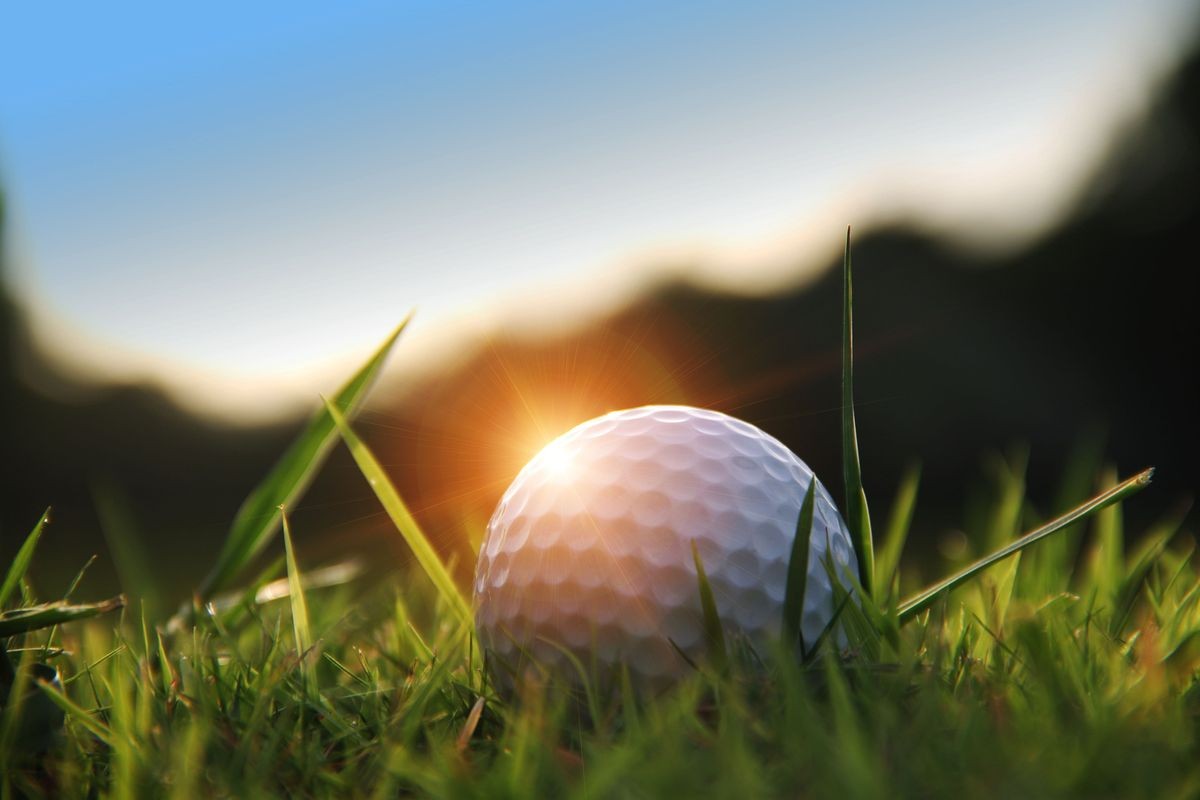 golf ball in beautiful golf course with sunset. Golf ball close up in golf coures at Thailand